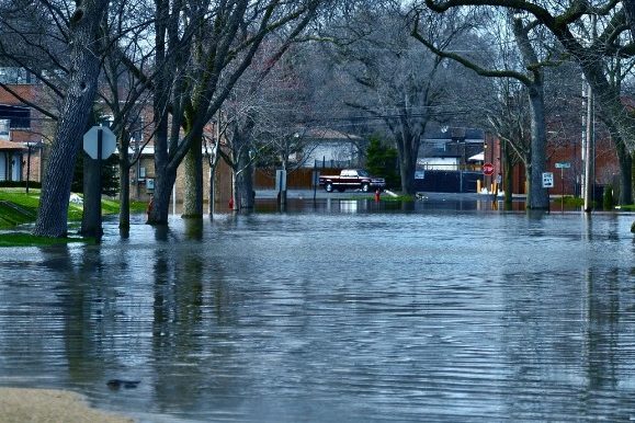 Calle inundada por lluvias intensas con el agua entrando en garajes y sótanos