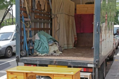 Carga de muebles en el camión Escritorio y muebles separados junto al camión para donación y reciclaje