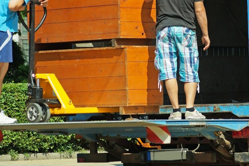Operarios cargando cajas en la plataforma elevadora Operarios de vaciados en Madrid subiendo cajas a la plataforma del camión