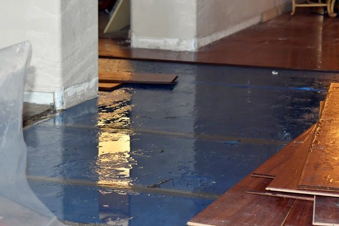 Lamas de tarima levantadas y suelo encharcado pendientes de retirar